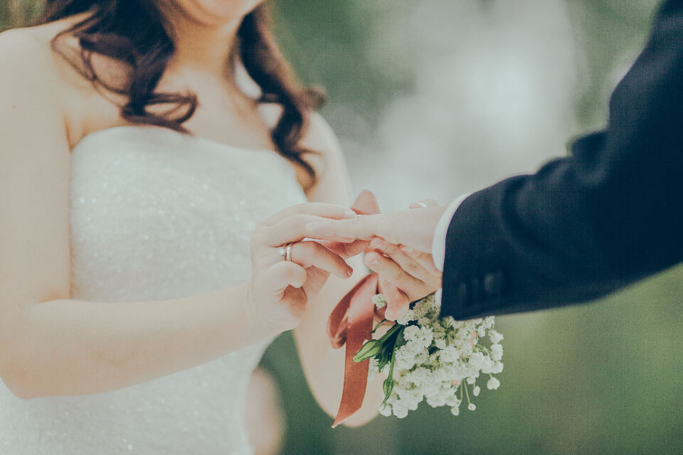 Novia entregando su mano al novio con un ramo de flores blancas